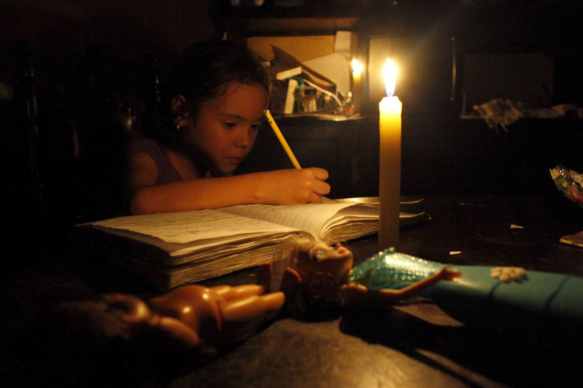 A girl does her homework by candlelight at his home during a power cut in San Cristobal, in the state of Tachira, Venezuela, April 25, 2016. REUTERS/Carlos Eduardo Ramirez. TPX IMAGES OF THE DAY