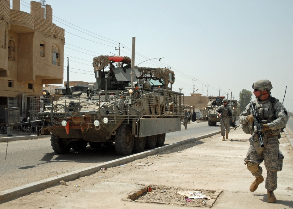 Staff Sgt. Andrew Frengel of Lebanon, Pa., other Soldiers and Stryker vehicles of A Troop, 2nd Squadron, 104th Cavalry Regiment, 56th Stryker Brigade Combat Team move through Sab al Bour, southwest of Taji, July 20. Pennsylvania Army National Guard Soldiers say they appreciate the versatility and the safety offered by the eight-wheeled vehicles after using them in Iraq since late January.