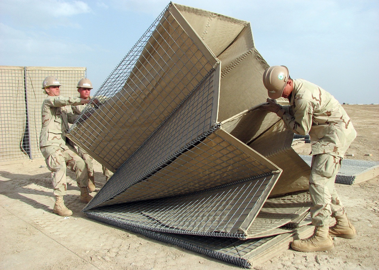 090411-N-8547M-025 U.S. Navy sailors assigned to Naval Mobile Construction Battalion 5 lift a collapsible wire mesh gabion into position at Camp Bastion, Afghanistan, on April 11, 2009. Naval Mobile Construction Battalion 5 is deployed to Afghanistan to provide contingency construction support to allies and members of the NATO International Security Assistance Force. Naval Mobile Construction Battalion 5 is one of the Naval Expeditionary Combat Command war fighting support elements providing host nation contingency construction support and security. DoD photo by Petty Officer 2nd Class Patrick W. Mullen III, U.S. Navy. (Released)